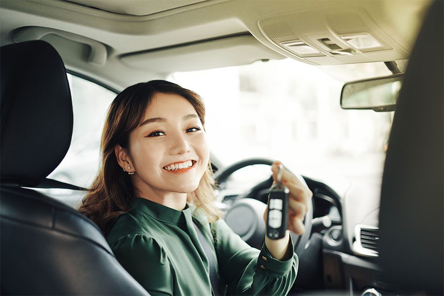 Add a Driver - Portrait of a Smiling Young Girl Sitting in Her New Car While Holding Up the Car Keys